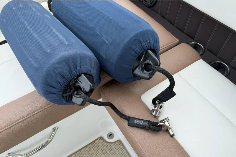 Slide: The Image of Blue boat fenders on a 2016 Cobalt 26SD, resting on brown and white seating. - 45