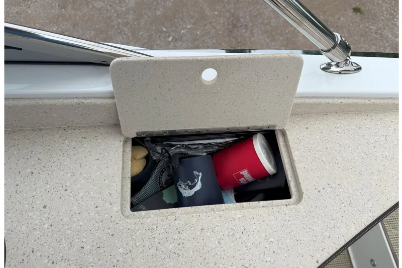 Slide: The Image of Storage compartment on 2016 Cobalt 26SD boat with various items inside. - 47