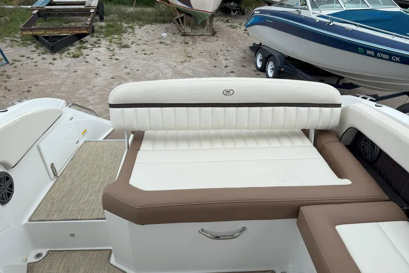 Slide: The Image of 2016 Cobalt 26SD boat interior with beige and brown seating, parked on a trailer. - 9