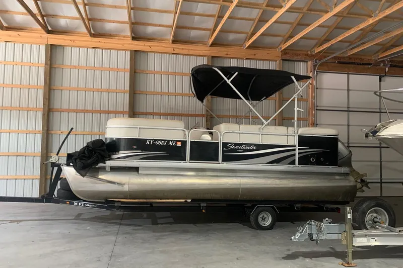 Slide: The Image of 2012 Sweetwater 2086 pontoon boat in storage, black canopy, trailer included. - 0