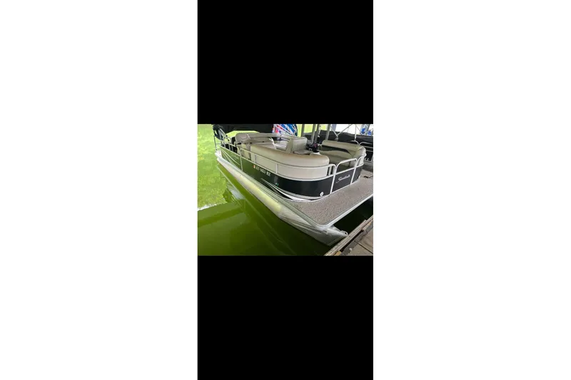 Slide: The Image of 2012 Sweetwater 2086 pontoon boat docked on calm green water. - 19