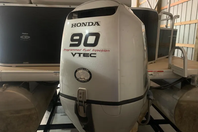 Slide: The Image of Honda 90 VTEC outboard motor on 2012 Sweetwater 2086 pontoon boat in storage. - 3