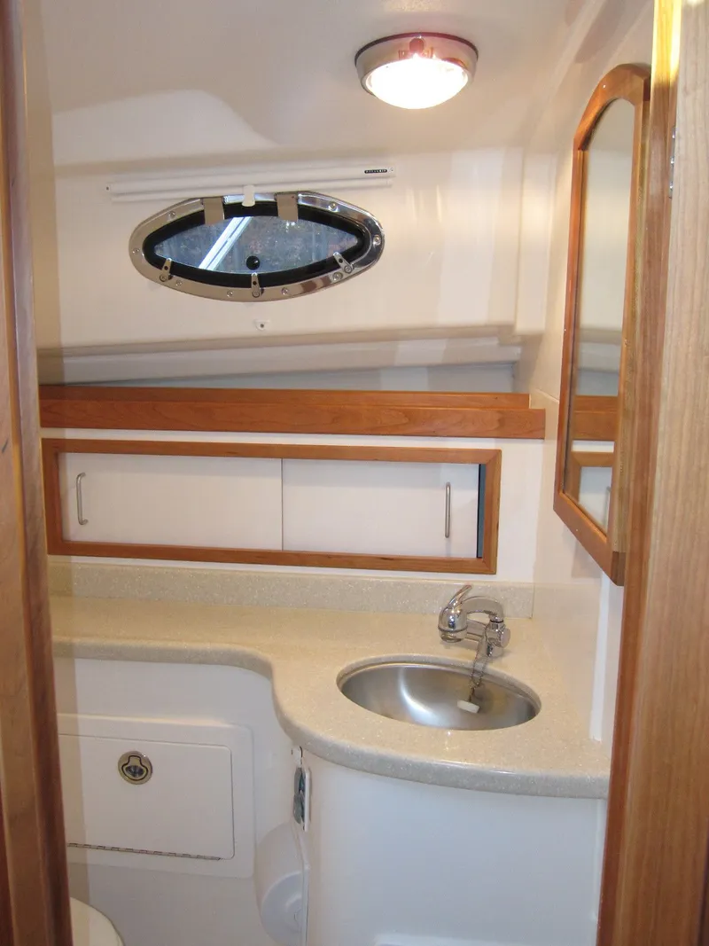 Slide: The Image of 2011 Back Cove 30 yacht bathroom with sink, mirror, and storage cabinets. - 13