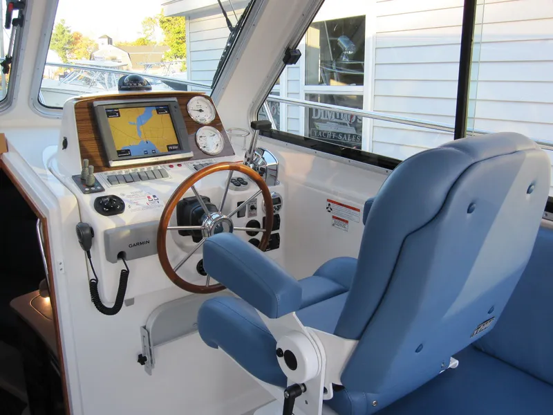 Slide: The Image of 2011 Back Cove 30 boat helm with blue captain's chair and navigation equipment. - 17