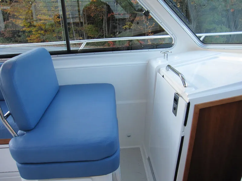 Slide: The Image of 2011 Back Cove 30 interior with blue seating and white cabinetry. - 18