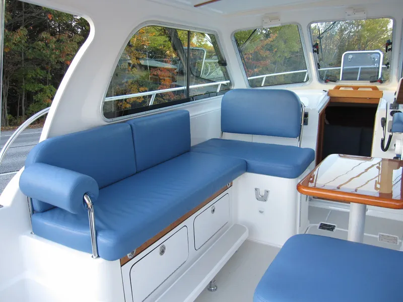 Slide: The Image of Interior of 2011 Back Cove 30 boat with blue seating and wooden table. - 19