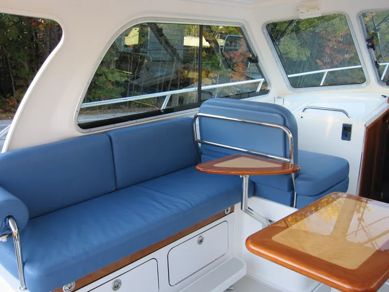 Slide: The Image of 2011 Back Cove 30 interior with blue seating and wooden table, showcasing elegant design. - 20