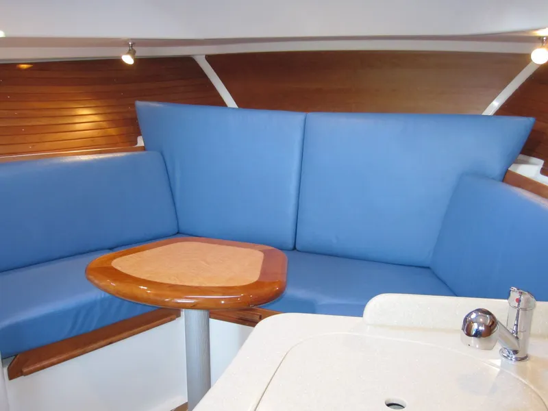 Slide: The Image of Interior of 2011 Back Cove 30 boat with blue seating and wooden table. - 6