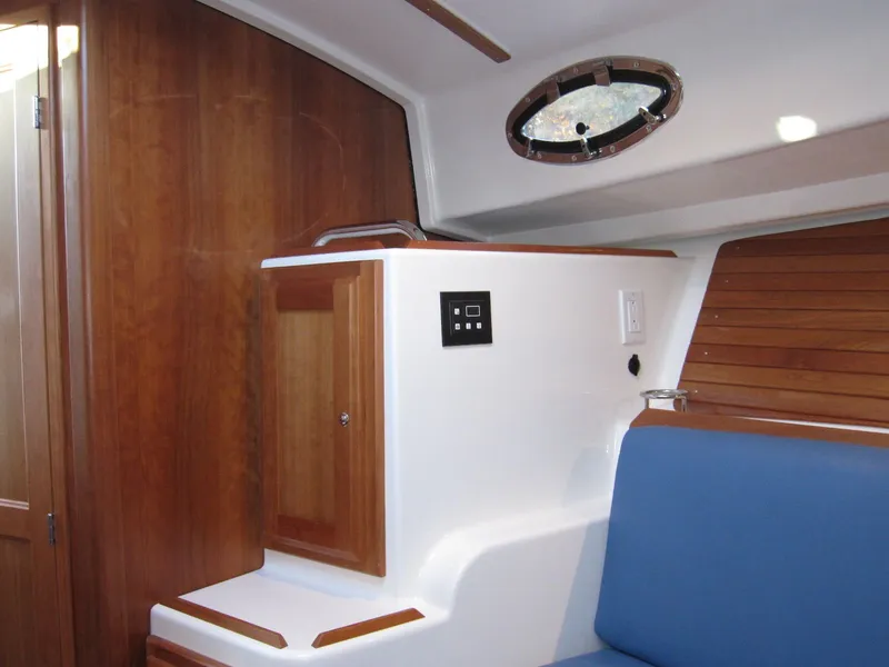 Slide: The Image of Interior of 2011 Back Cove 30 boat with wood paneling and blue seating. - 8
