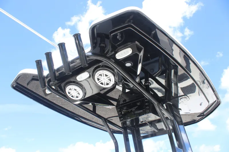Slide: The Image of Tidewater 232 LXF 2026 boat T-top with rod holders and speakers against blue sky. - 8