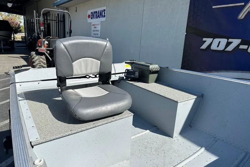 Slide: The Image of 2024 Lund WC-14 boat interior with a comfortable gray seat and storage area. - 11