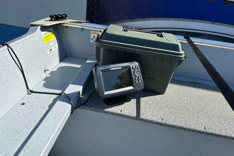 Slide: The Image of 2024 Lund WC-14 boat interior with Lowrance fish finder and storage box. - 13