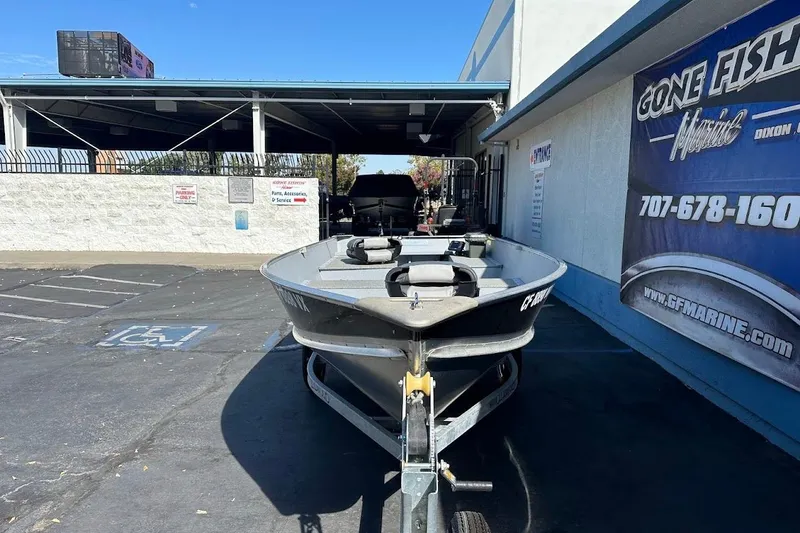 Slide: The Image of 2024 Lund WC-14 boat on trailer at marine dealership parking lot. - 3