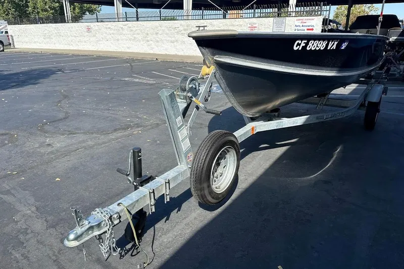 Slide: The Image of 2024 Lund WC-14 boat on trailer in parking lot, side view. - 4