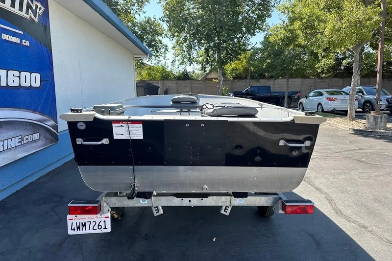 Slide: The Image of 2024 Lund WC-14 boat on trailer, parked outdoors near a building. - 6