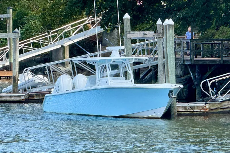 Slide: The Image of 2021 Jupiter 38 HFS boat docked at a marina with lush greenery. - 1