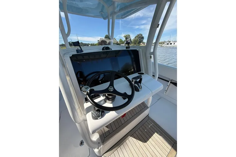 Slide: The Image of 2021 Jupiter 38 HFS boat helm with steering wheel and controls, docked by the water. - 10