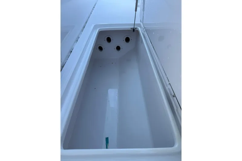Slide: The Image of Livewell compartment on a 2021 Jupiter 38 HFS boat, featuring multiple drainage holes. - 16