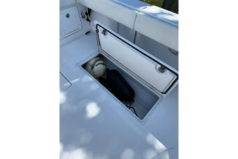Slide: The Image of Open storage compartment on 2021 Jupiter 38 HFS boat, containing fenders and a buoy. - 19