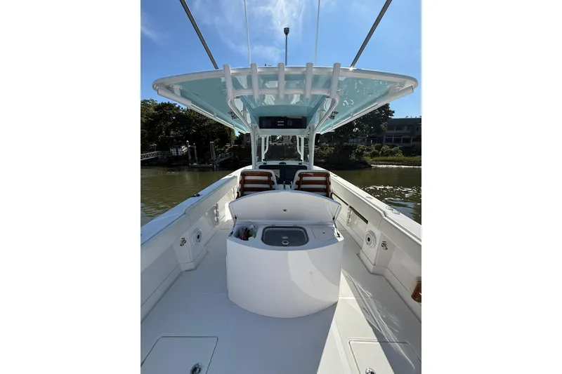 Slide: The Image of 2021 Jupiter 38 HFS boat interior with seating and console, under a clear blue sky. - 32