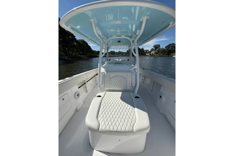 Slide: The Image of 2021 Jupiter 38 HFS boat interior with cushioned seating and overhead canopy on a sunny day. - 38