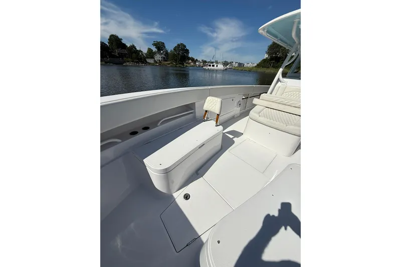Slide: The Image of 2021 Jupiter 38 HFS boat interior with seating, on a calm waterway under blue skies. - 42