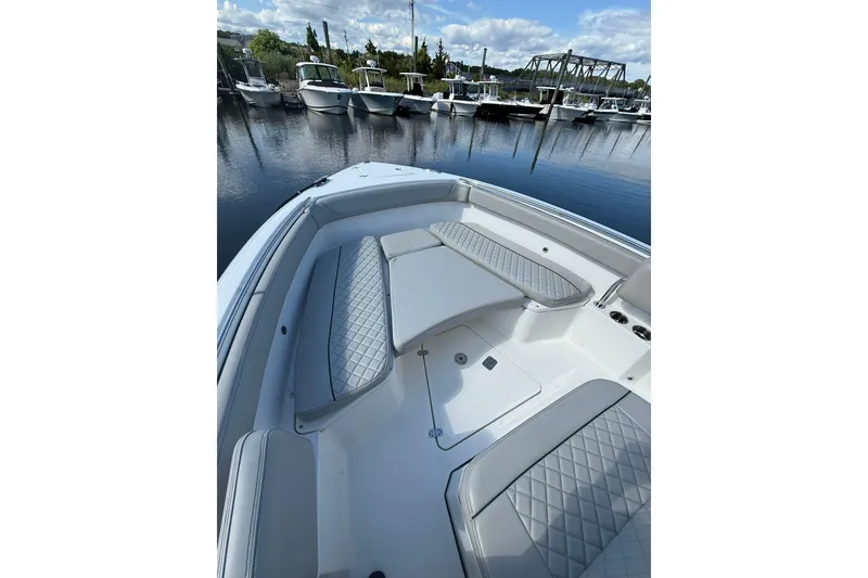 Slide: The Image of 2021 Jupiter 38 HFS boat interior with cushioned seating, docked at marina. - 46