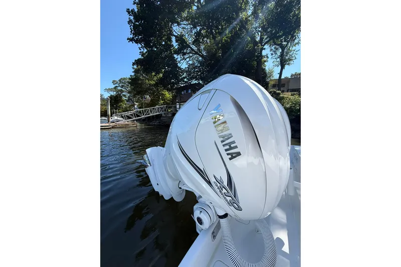 Slide: The Image of Yamaha outboard engine on 2021 Jupiter 38 HFS boat, docked by trees. - 8