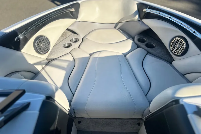 Slide: The Image of Interior of a 2008 Malibu Boats 23 LSV, featuring cushioned seating and built-in speakers. - 5