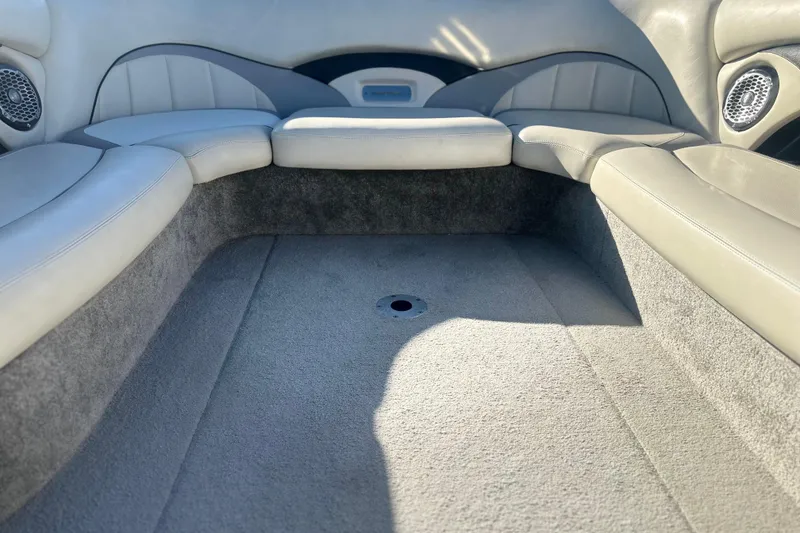 Slide: The Image of Interior seating of a 2008 Malibu Boats 23 LSV, featuring gray upholstery and speakers. - 8