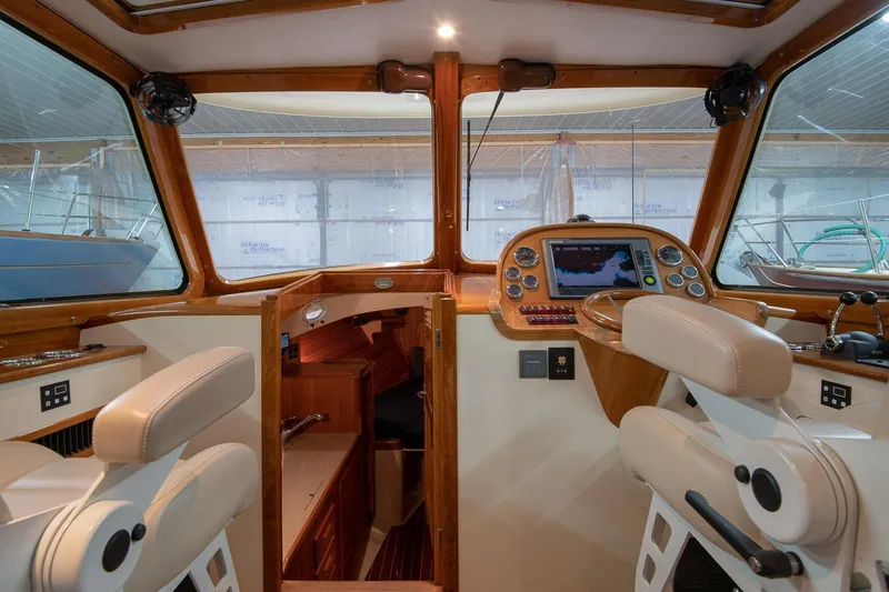 Slide: The Image of Interior of 2011 Hinckley Picnic Boat 37 MKIII with elegant wood finish and striped seating. - 5