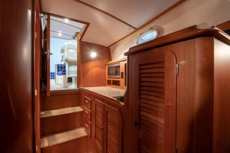 Slide: The Image of Interior cabin of 2011 Hinckley Picnic Boat 37 MKIII with blue cushions and wooden paneling. - 9