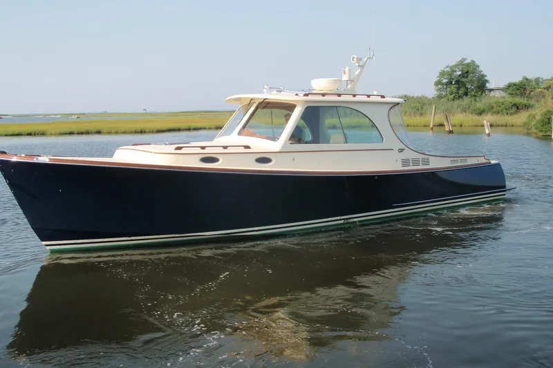 Slide: The Image of 2011 Hinckley Picnic Boat 37 MKIII cruising near a scenic shoreline. - 15