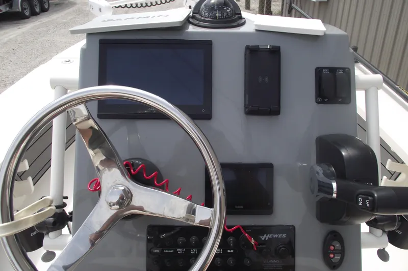 Slide: The Image of 2024 Hewes Redfisher 16 boat dashboard with steering wheel and navigation controls. - 16