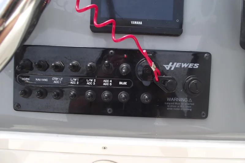 Slide: The Image of 2024 Hewes Redfisher 16 control panel with switches and safety lanyard. - 17