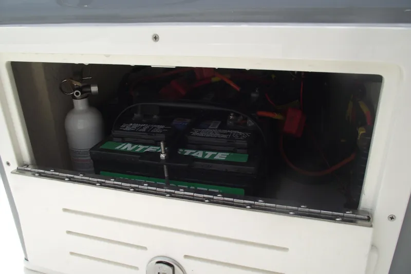 Slide: The Image of 2024 Hewes Redfisher 16 battery compartment with fire extinguisher and wiring. - 18