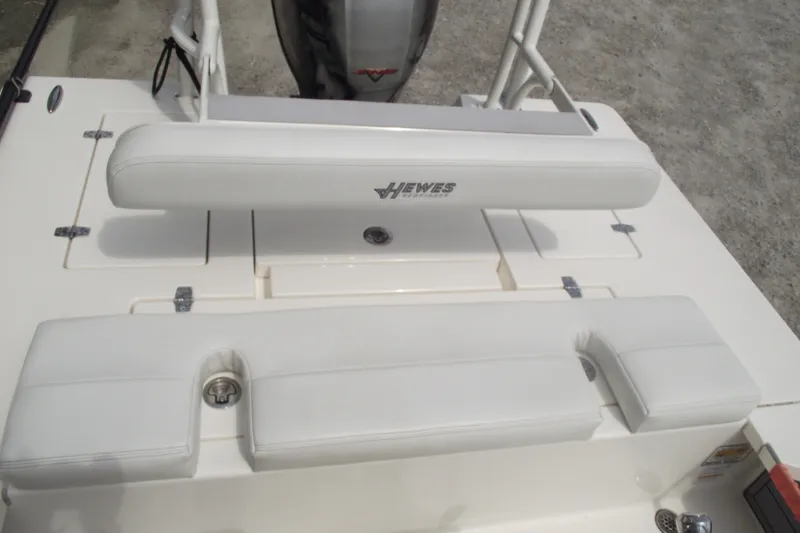 Slide: The Image of 2024 Hewes Redfisher 16 boat interior with white cushioned seating and storage compartments. - 19