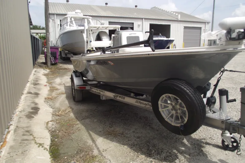 Slide: The Image of 2024 Hewes Redfisher 16 boat on trailer, parked outside a storage facility. - 2
