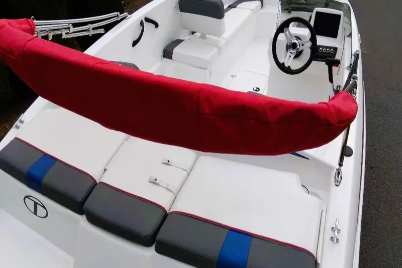Slide: The Image of 2024 Tahoe T16 boat interior with red accents, steering wheel, and seating. - 4