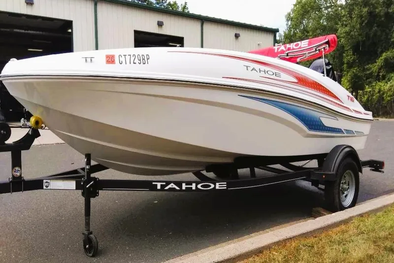 Slide: The Image of 2024 Tahoe T16 boat on trailer, parked outdoors near a building. - 5