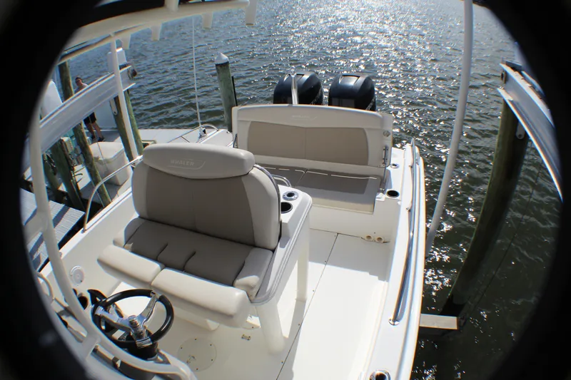 Slide: The Image of 2017 Boston Whaler 270 Dauntless boat interior with seating and dual engines on water. - 14
