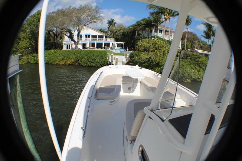 Slide: The Image of 2017 Boston Whaler 270 Dauntless boat docked near waterfront homes, surrounded by lush greenery. - 15