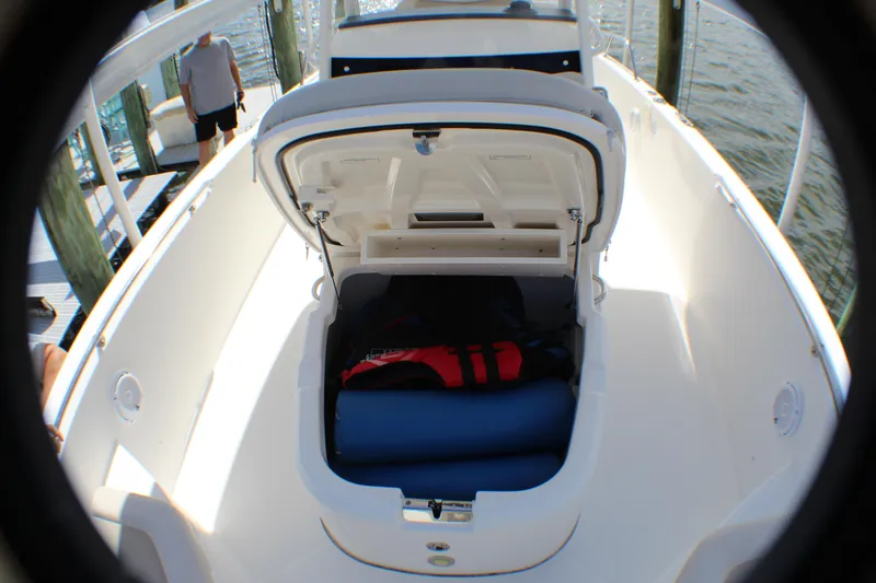 Slide: The Image of 2017 Boston Whaler 270 Dauntless boat with open storage compartment, docked by the water. - 18