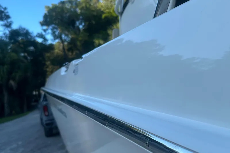 Slide: The Image of 2017 Boston Whaler 270 Dauntless boat side view with trees in the background. - 4