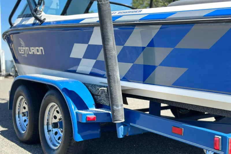 Slide: The Image of 2001 Centurion Elite Bowrider boat on trailer, featuring blue and white design. - 4