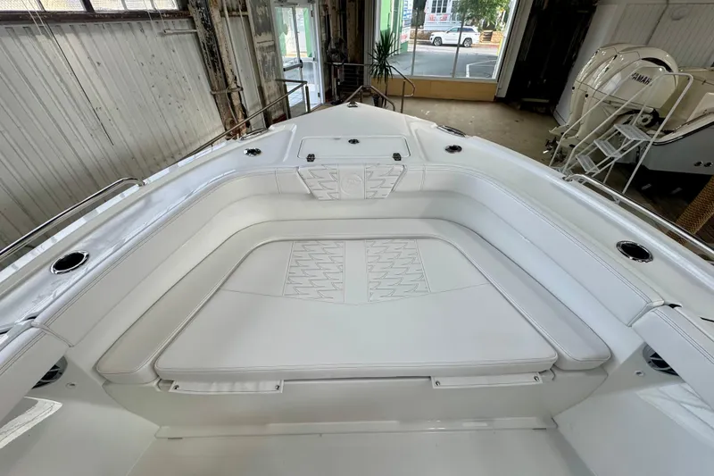 Slide: The Image of 2026 Parker 23SE Center Console boat with spacious white seating in a showroom. - 10