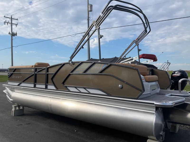 Slide: The Image of 2022 Crest Caribbean LX 230 SLS pontoon boat with sleek design, parked outdoors. - 2
