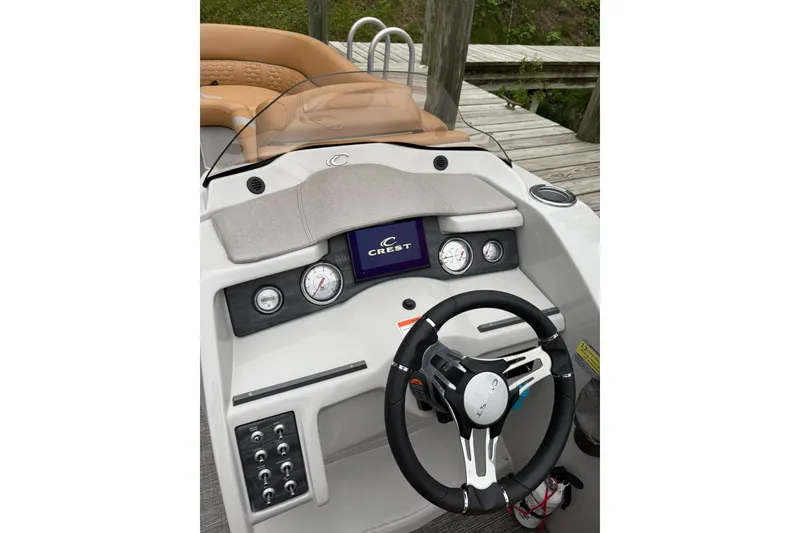 Slide: The Image of 2022 Crest Caribbean LX 230 SLS boat dashboard with steering wheel and gauges. - 22