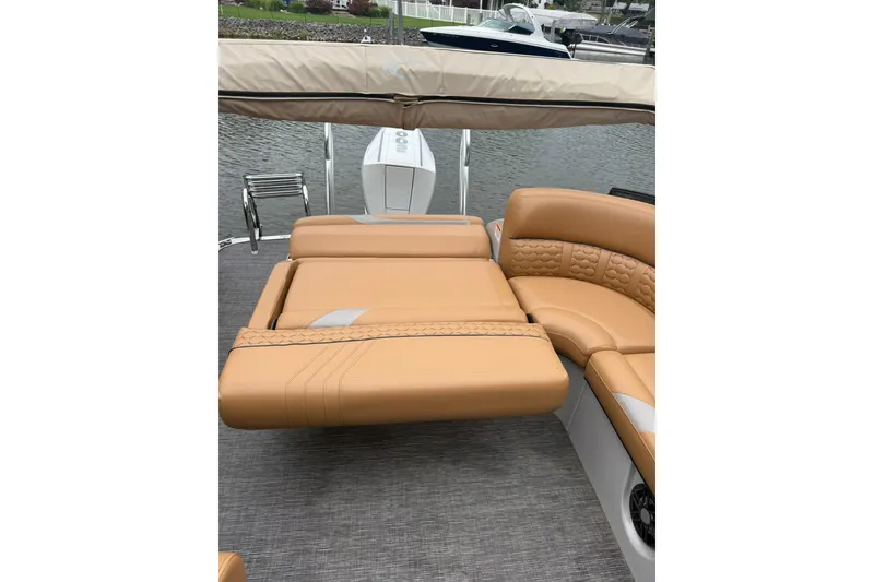 Slide: The Image of 2022 Crest Caribbean LX 230 SLS boat with tan leather seating and water backdrop. - 26