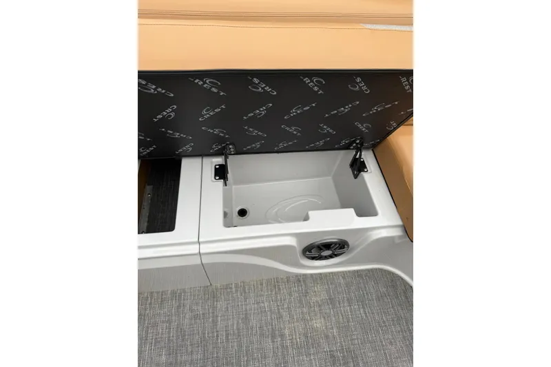 Slide: The Image of 2022 Crest Caribbean LX 230 SLS boat storage compartment with open seat and speaker. - 27